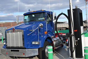 Photo of long haul truck cab refueling at a natural gas station.