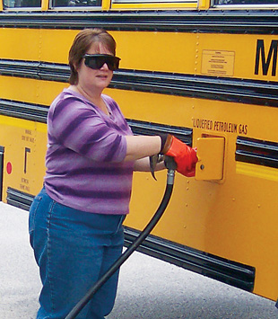 Driver Sandy Fecteau fuels one of MSAD 6's 10 propane school buses. <em>Photo from Maine School Administrative District No. 6, NREL/PIX 21778</em>