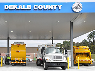 Three refuse haulers filling up at a natural gas fueling station.