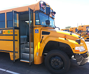 Photo of a yellow school bus with the door to the bus open.